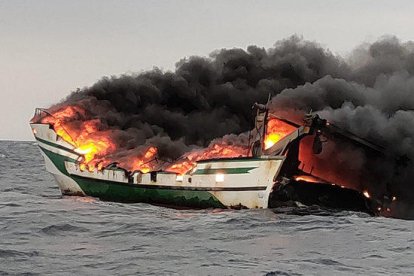 Plano detalle de la embarcación quemando en el mar en el Port de la Selva.