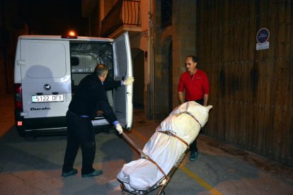 Trabajadores de la funeraria se llevan el cadáver.