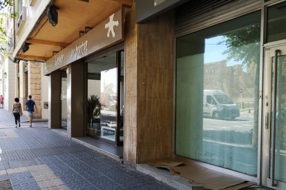 El hombre duerme en encima un cartón, al lado de la tienda.