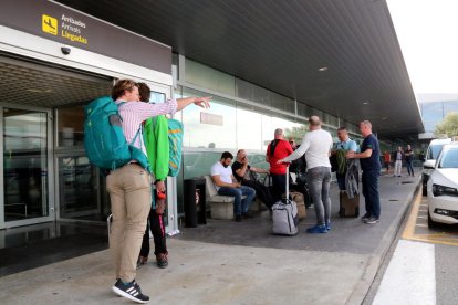 Turistas con maletas en la puerta del Aeropuerto de Reus.