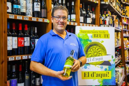 Eduard Jordà mostra una botella del licor d'herbes que ha creat amb segell tarragoní.