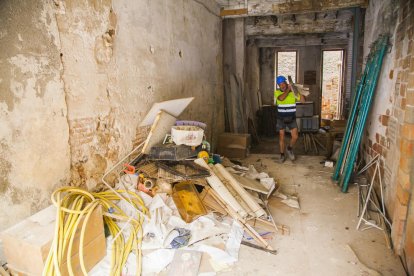 Operaris treballen per enviar al reciclatge les deixalles acumulades a l'interior de l'immoble.