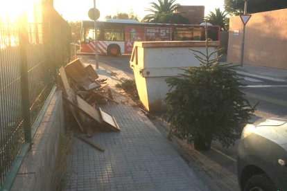 Estado de la acera, con los trastos y el árbol de Navidad 'aparcado'.