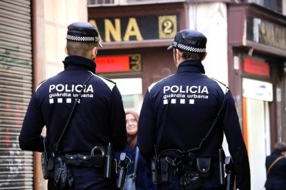 Dos agentes de la Guardia Urbana patrullando para|por Barcelona.