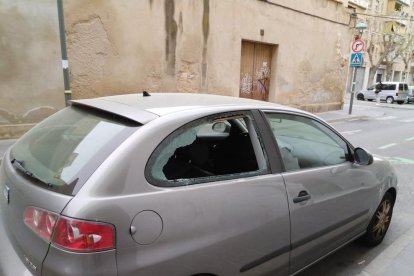 Imagen de un turismo afectado, con el cristal de una ventana roto.