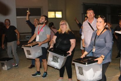 Varias personas muestran las urnas con sobres sin papeleta una vez acabadas las votaciones en el Instituto Antoni de Martí i Franquès de Tarragona, el 1 de octubre del 2017.