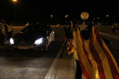 Un dels membres del CDR anima a un cotxe a passar pel peatge de Martorell.