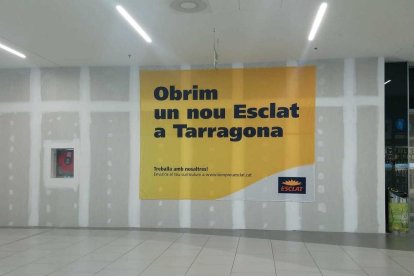 Un cartell anuncia la nova apertura d'un Esclat al Parc Central.