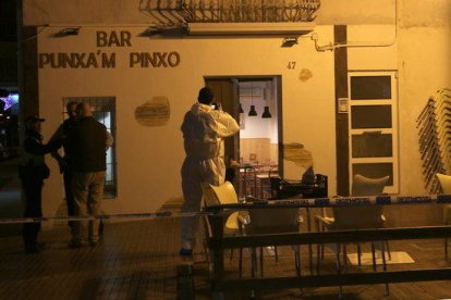 Un agente de la policía científica de los Mossos haciendo fotos de la fachada del bar Punxa'm Pinxo de Sant Carles de la Ràpita el 13 de diciembre de 2017.