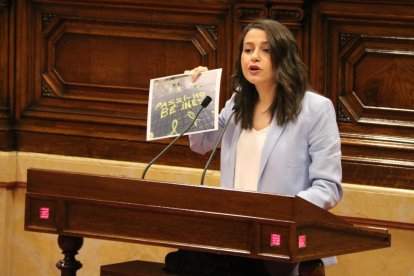 La líder de Cs, Inés Arrimadas, enseña un cartel desde el atril del Parlamento, durante su última intervención al pleno de la cámara.