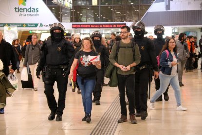 Dos personas siendo desalojadas de la estación de Sants durante la protesta convocada por los CDR.