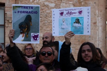 Dos manifestants alçant cartells reivindicatius en la protesta per la mort d'un rottweiler abatut per la Policia Local de Calafell.