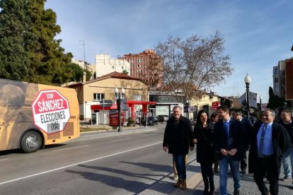 Els membres del grup municipal de Ciutadans i el diputat Domínguez i, a l'esquerra, l'autobús.