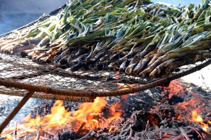 Calçots en una graella durant la cocció en un dels restaurants de Valls a l'Alt Camp.