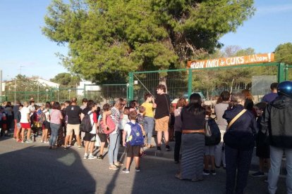 Imatge de diversos alumnes i els seus pares davant l'Escola l'Arrabassada el primer dia del curs 2019-202.