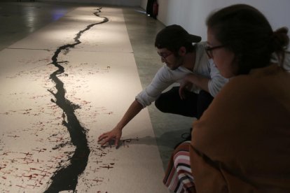 Jacinto Hierro y Priscila Alegre observando de cerca el mural sobre los muertos de la N-340.