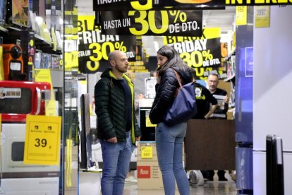 Una pareja en una tienda de electrodomésticos el 'Black Friday'.