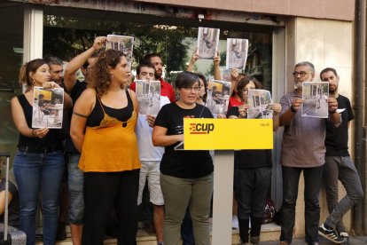 Un moment de la roda de premsa quan diverses persones vinculades a la CUP han mostrat fotografies dels suposats agents que els espien.