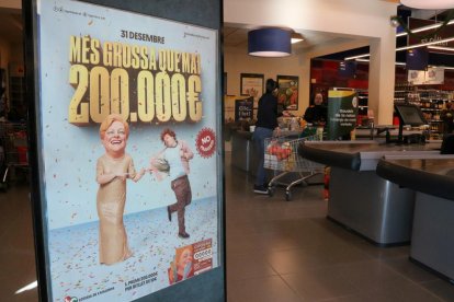 Un plafó amb un cartell de la Grossa de Cap d'Any en un supermercat.