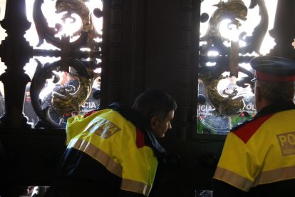 La porta del Parlament tancada des de dins amb Mossos mirant pels vidres.