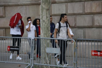 Plano general de tres de los acusados, acompañados de una familiar, llegando a la Audiencia de Barcelona.