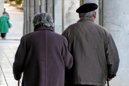 Imatge d'arxiu de dos persones grans passejant de la mà