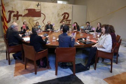 Imagen de la reunión del consejo ejecutivo. El presidente y los consellers muestran unas cartulinas con fragmentos de poemas que la consellera Borràs les ha repartido.