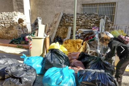 Imagen de una voluntaria acumulando la basura recogida.