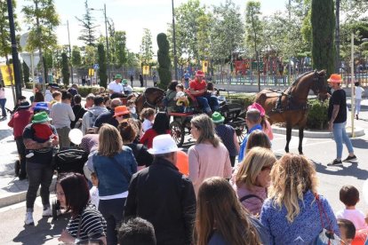 Los asistentes pudieron dar una vuelta para|por el pueblo con carros de caballos.