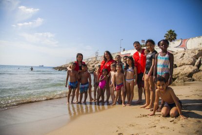 Fotografía familia de los niños del centro de verano con los monitores de Cruz Roja, ayer, en la playa del Milagro.