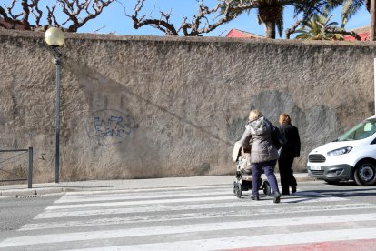 Imatge d'unes àvies, d'esquena, amb un cotxet de nen petit, travessant un pas de vianants al centre de Valls, en un punt on es vol renovar l'enllumenat