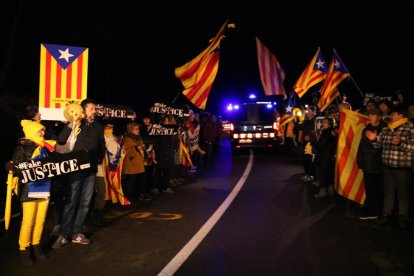 Pla general de gent, amb estelades, de matinada, acomiadant Carme Forcadell, en el seu trasllat des de la presó de Mas d'Enric al Catllar a Brians 2, en comitiva de vehicles i furgons dels Mossos d'Esquadra. Imatge de l'1 de febrer del 2019