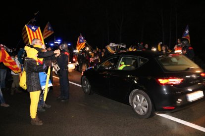 Plano general de gente, con esteladas, de madrugada, despidiendo a Carme Forcadell en Mas Enric.