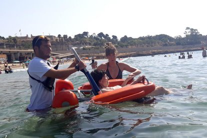 Una de las usuarias en una silla anfibia en la playa del Milagro.