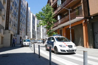 Un vehicle dels Mossos d'Esquadra davant l'edifici del carrer Burriac del barri de Cerdanyola de Mataró, on va aparèixer morta la nena de 13 anys.