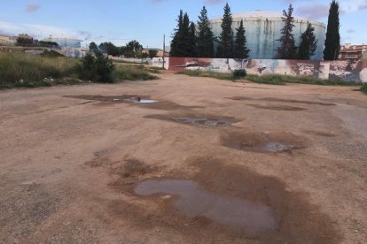 Els forats i les pedres predominen al descampat situat a l'entrada de l'escola.