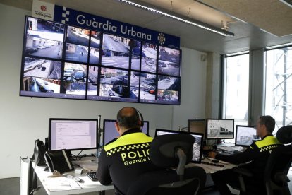 Dos agentes de la Guardia Urbana de Tarragona trabajando en la sala de control de la comisaría.