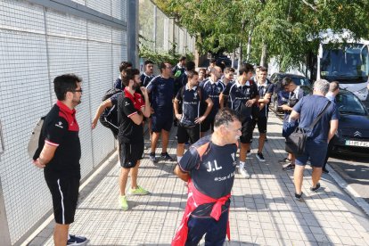 Los jugadores y cuerpo técnico del Rubí y los árbitros esperando fuera del campo.