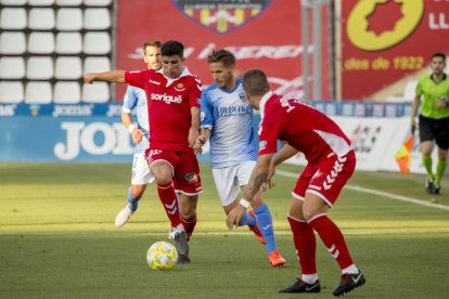 Óscar Sanz, que va debutar com a jugador del Nàstic, durant una acció amb l'exgrana Marc Martínez, al Camp d'Esports de Lleida.