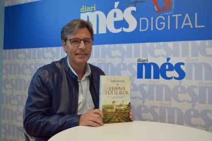 Jordi Nogués sostiene en sus manos un ejemplar de la novela 'L'espasa i la llavor'.