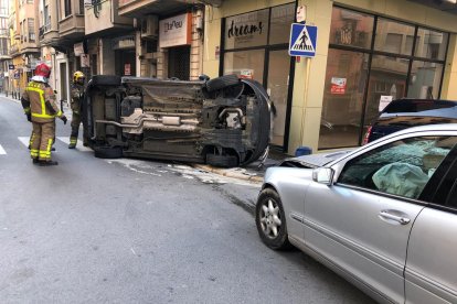 Pla general dels vehicles accidentats, un d'ells bolcats després del xoc.