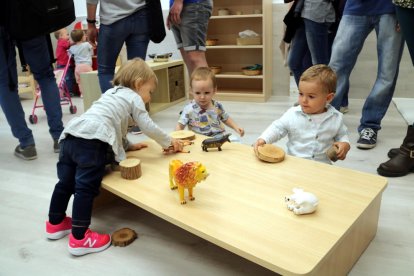 Tres niños que juegan en una mesa de un jardín de infancia.