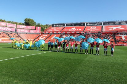 Els futbolistes dels dos conjunts van sortir al terreny de joc amb un paraigua blau.