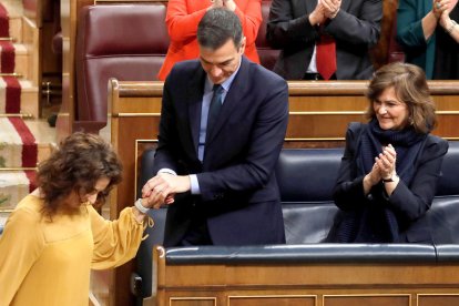 La ministra d'HIsenda, María Jesús Montero, es felicitada pel president del Govern, Pedro Sánchez, i la vicepresidenta, Carmen Calvo