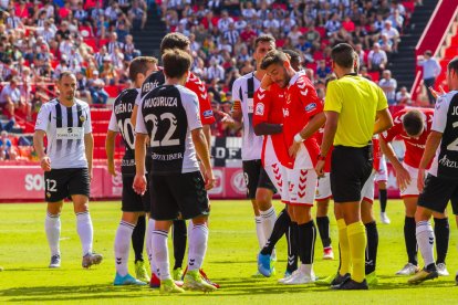 Jugadors del Nàstic i del Castellón esperen que una jugada a pilota aturada doni el tret d'inici.