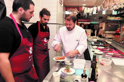 Uno de los chefs invitados dando consejos a dos cocineros de uno de los establecimientos participantes.