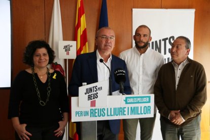 El cap de llista de Junts per Reus, Carles Pellicer, acompanyat de membres del partit en la roda de premsa per valorar pactes postelectorials.