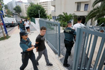 Els detinguts per una presumpta agressió sexual en grup a Benidorm entren custodiats a l'edifici on van succeir els fets.