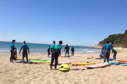 Imatge d'un grup d'alumnes en una classe de surf.