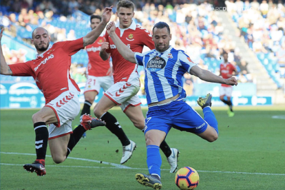 Mikel Villanueva intenta evitar un chute de Quique.